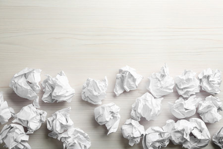 Crumpled sheets of paper on light wooden background, flat lay. Space for textの写真素材