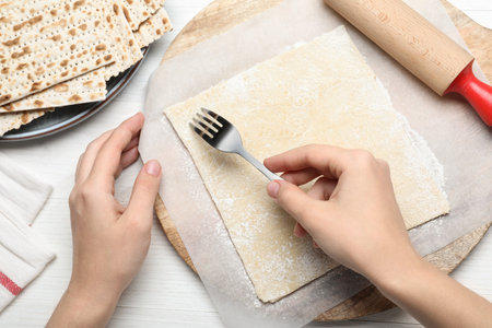 Woman making traditional matzo at white wooden table, top viewの写真素材