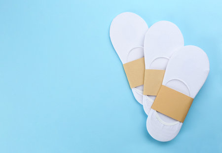 White cotton socks on light blue background, flat lay. Space for textの写真素材