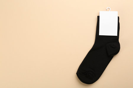 Pair of black cotton socks on beige background, top view. Space for textの写真素材