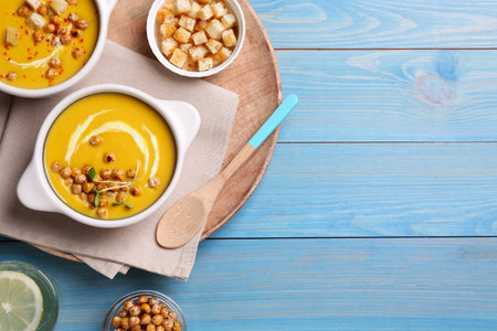 Delicious cream soup with chickpeas on light blue wooden table, flat lay. Space for textの写真素材
