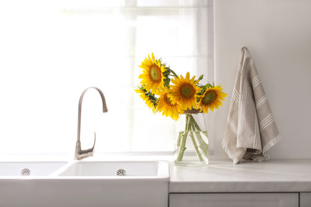 Vase with beautiful yellow sunflowers in the kitchenの写真素材