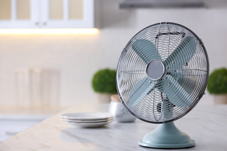 Modern electric fan on countertop in kitchen, space for text. summer heatの写真素材