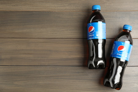 MYKOLAIV, UKRAINE - FEBRUARY 9, 2021: Bottles of Pepsi on wooden table, flat lay. Space for textのeditorial素材