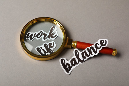 Magnifying glass on gray table. Life work balance conceptの写真素材