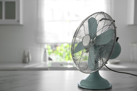 Modern electric fan on white marble table indoors, space for text. summer heatの写真素材