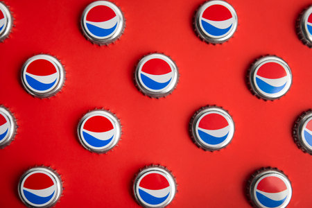 MYKOLAIV, UKRAINE - FEBRUARY 11, 2021: Pepsi lids on red background, flat layのeditorial素材