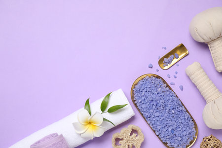 Beautiful spa composition with sea salt on violet background, flat lay. Space for textの写真素材