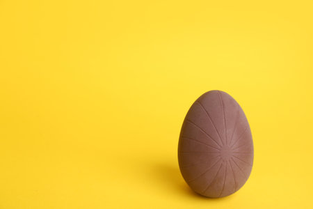 Sweet chocolate egg on yellow background. Space for textの写真素材