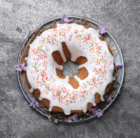 Glazed Easter cake with sprinkles on gray table, top view