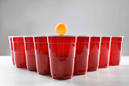 Plastic cups and balls for beer pong on white tableの写真素材