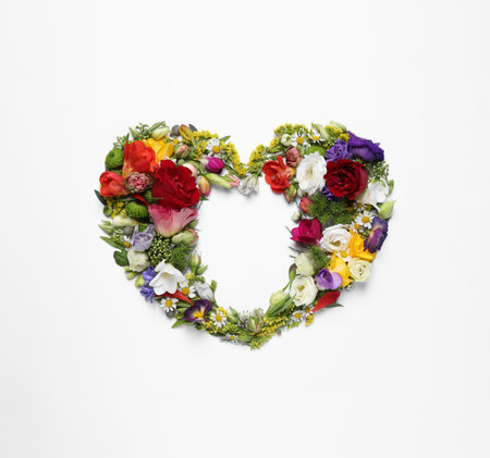 Beautiful heart made of different flowers on white background, top viewの写真素材