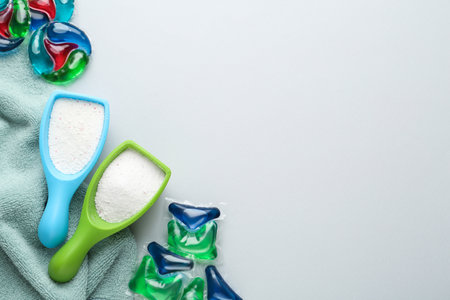 Laundry capsules, detergent powder and towel on light gray background, flat lay. Space for textの写真素材