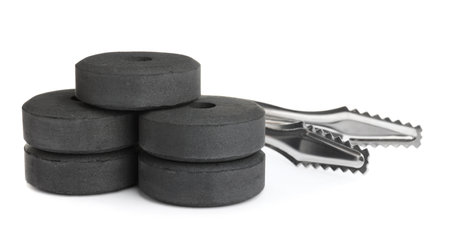 Charcoal rings for hookah and tongs on white backgroundの写真素材