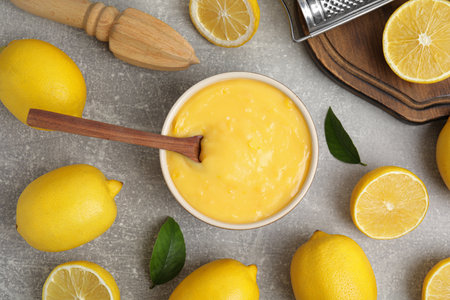 Delicious lemon curd and fresh fruits on light gray table, flat layの写真素材