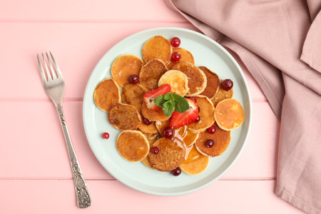 Cereal pancakes with berries served on pink wooden table, flat layの写真素材