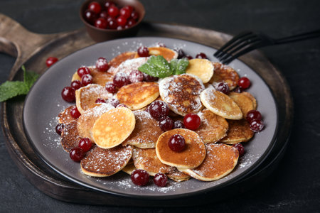 Cereal pancakes with cranberries served on black tableの写真素材