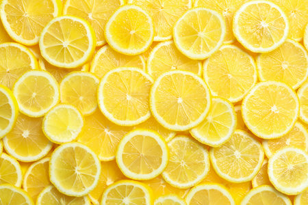 Many fresh juicy lemon slices as background, top viewの写真素材