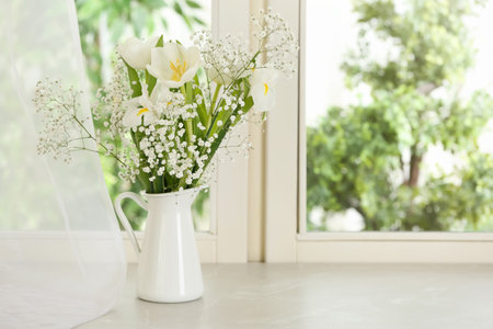 Beautiful fresh flowers on window sill indoors. Space for textの写真素材