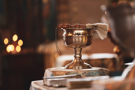 Silver vessel with holy water and brush on stand in church, space for text. Baptism ceremonyの写真素材