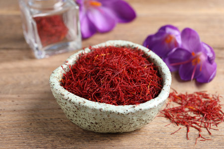 Dried saffron and crocus flowers on wooden tableの写真素材
