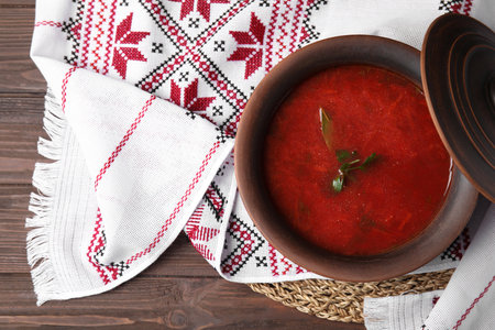 Clay pot with Ukrainian borsch and rushnyk on table, top viewの写真素材