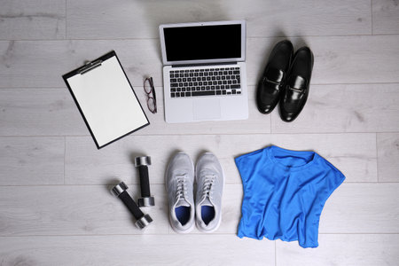 Flat lay composition of business items with sport accessories on white wooden background. Life and work balance conceptの写真素材