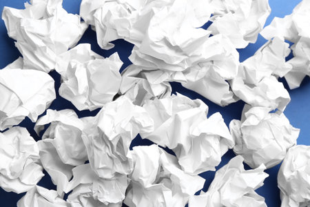 Crumpled sheets of paper on blue background, closeupの写真素材