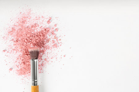Makeup brush and scattered blush on white background, top view. Space for textの写真素材