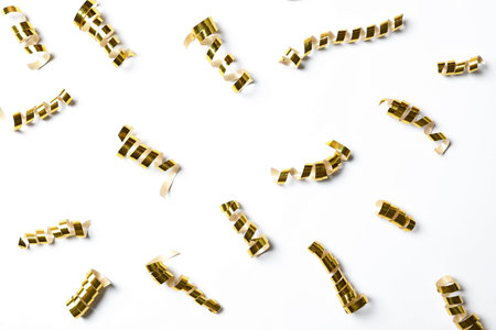 Shiny golden serpentine streamers on white background, top viewの写真素材