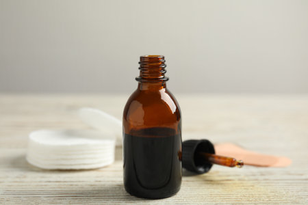 Bottle of medical iodine and dropper on white wooden tableの写真素材