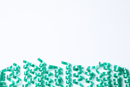 Turquoise serpentine streamers on white background, top viewの写真素材