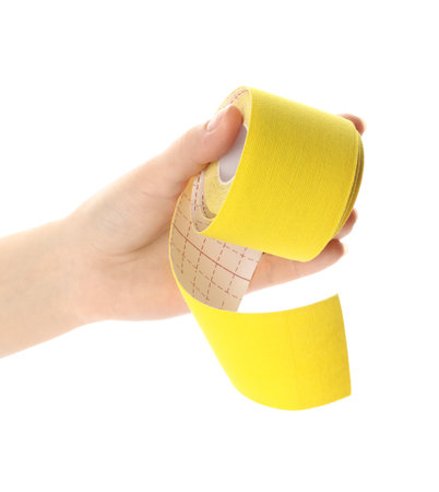 Woman with bright kinesiology tape in roll on white background, closeupの写真素材