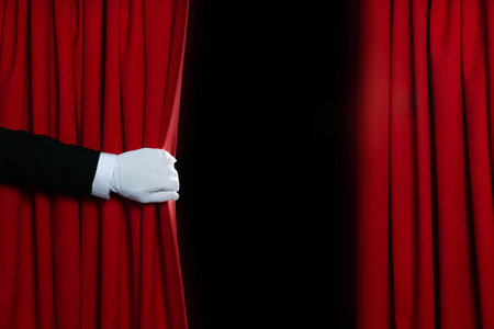 Person opening red front curtains on black background, closeupの写真素材