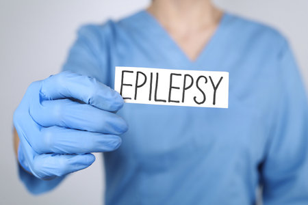 Doctor holding card with word Epilepsy on light gray background, closeupの写真素材