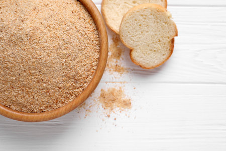 Fresh breadcrumbs on white wooden table, flat layの写真素材