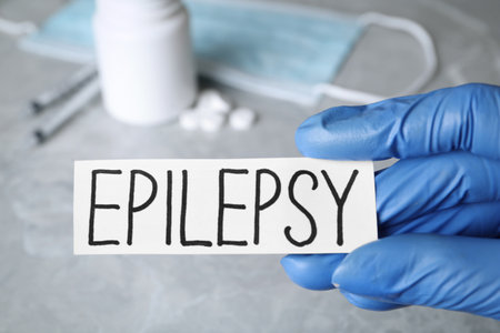 Doctor holding card with word Epilepsy at gray table, closeupの写真素材