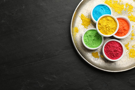 Colorful powder dyes on black background, top view with space for text. Holi Festivalの写真素材