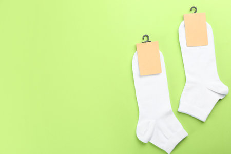 Soft cotton socks on light green background, flat lay. Space for textの写真素材