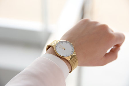 Woman with luxury wristwatch on blurred background, closeupの写真素材