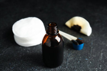 Bottle of medical iodine, cotton pads and buds on black table, closeupの写真素材