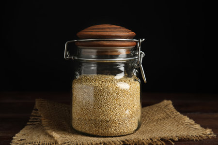 Jar with white quinoa on wooden tableの写真素材