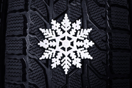 Winter tire with snowflake as background, closeupの写真素材