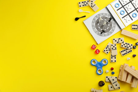 Different types of board games and its' components on yellow background, flat lay. Space for textの写真素材