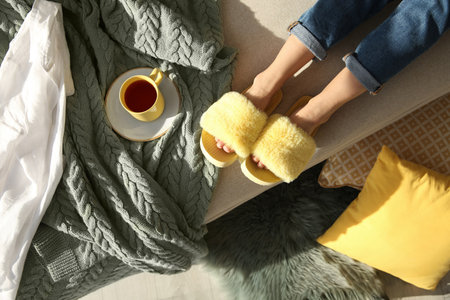 Woman with cup of tea wearing soft comfortable slippers at home, top viewの写真素材