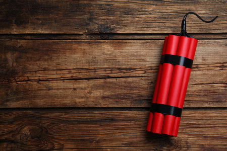 Red explosive dynamite bomb on wooden background, top view. Space for textの写真素材