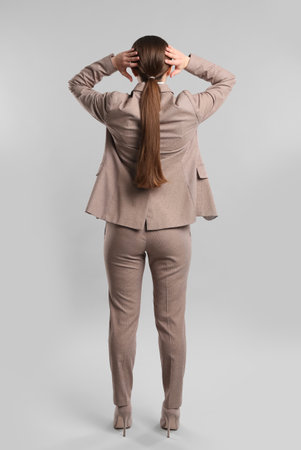 Young woman on gray background, back viewの写真素材