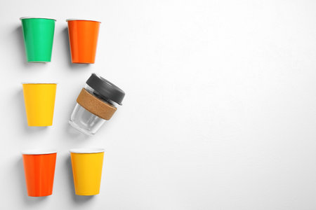 One reusable and other disposable cups on white background, flat lay. Space for textの写真素材