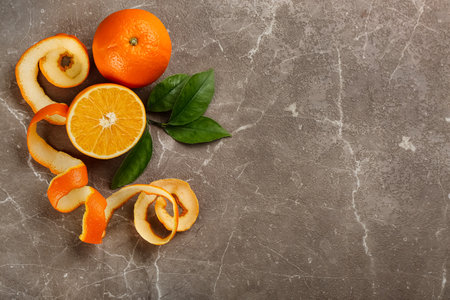 Orange fruits with peel on gray marble table, flat lay. Space for textの写真素材