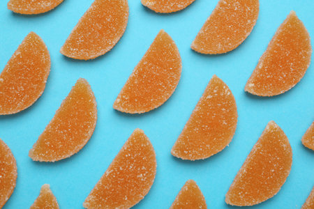 Delicious orange marmalade candies on light blue background, flat layの写真素材